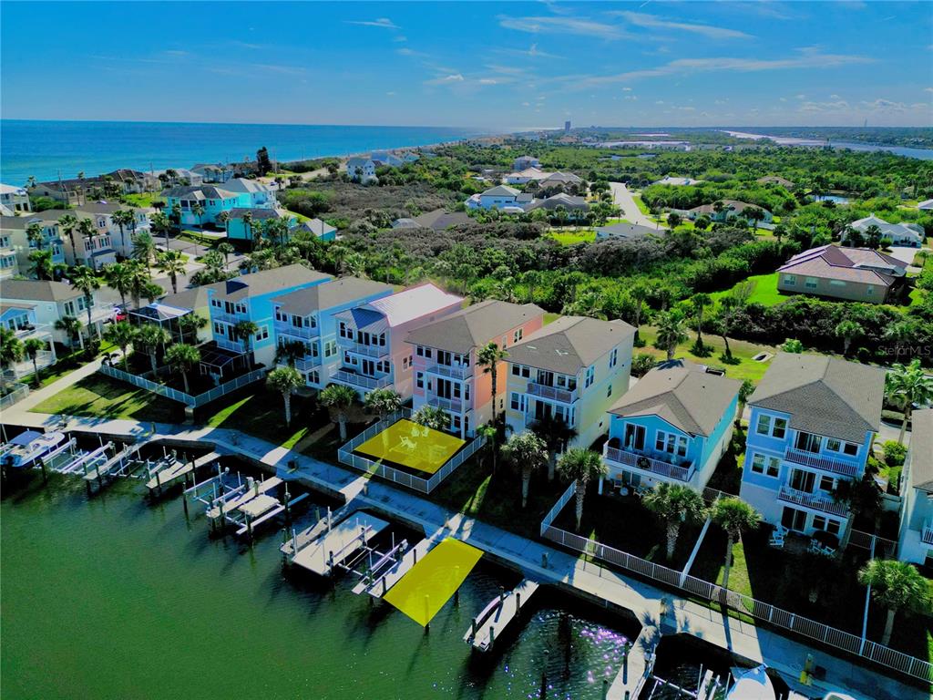 An aerial view shows a row of colorful waterfront houses with private docks and boat lifts — 2727 MORNING LIGHT COURT, FLAGLER BEACH, FL