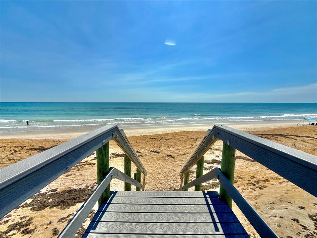 A three-story pink house with a two-car garage sits between two other residential homes — 2727 MORNING LIGHT COURT, FLAGLER BEACH, FL