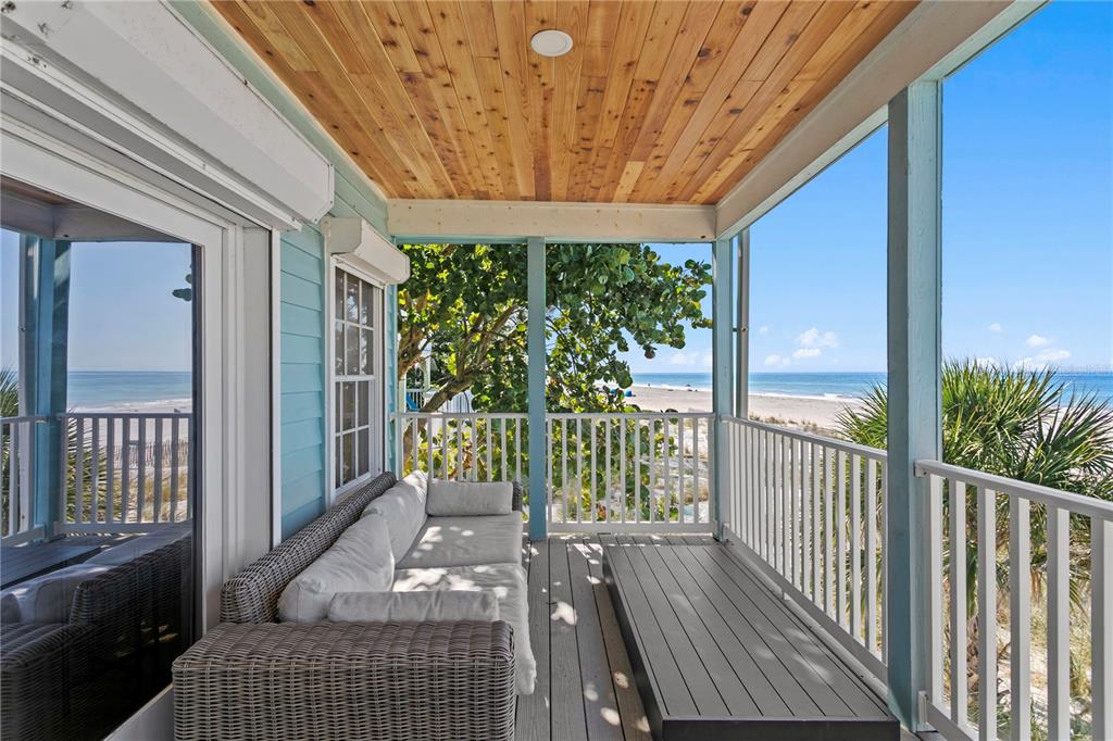 A view of the ocean from a covered, paved patio framed by light blue support columns — 20060 GULF BOULEVARD, INDIAN SHORES, FL
