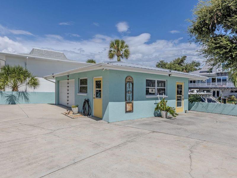 A light blue, single-story detached garage with a yellow door and a metal roof — 918 GIBBS ROAD, VENICE, FL