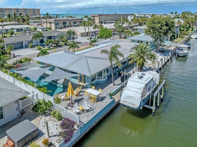 An aerial view of a waterfront house with a pool, patio, and boat lift — 918 GIBBS ROAD, VENICE, FL