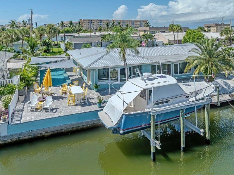 An aerial view shows a waterfront house with a pool, patio, and boat on a lift — 918 GIBBS ROAD, VENICE, FL