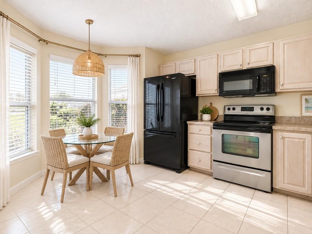 A spacious living room features beige carpeting, a ceiling fan, and two sliding glass doors — 4967 HERON RUN CIRCLE, LEESBURG, FL