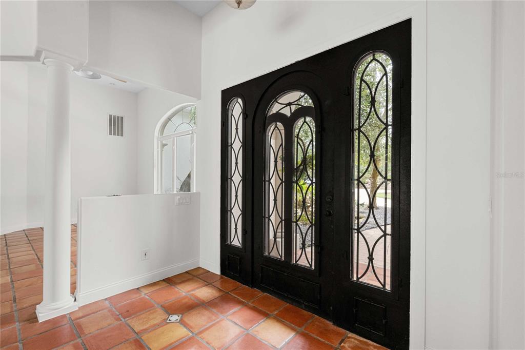 An entryway features terracotta tile flooring, a white column, and a black arched double door — 17401 S HIGHWAY 475, SUMMERFIELD, FL