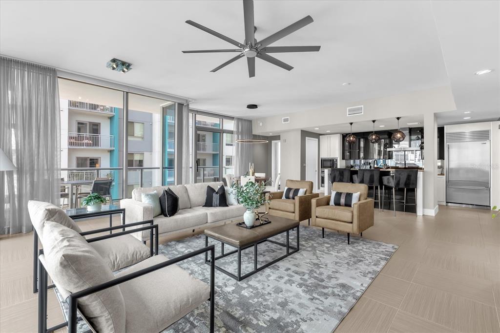 A modern living room with a large area rug, neutral furniture, and an open kitchen — 260 S OSCEOLA AVENUE UNIT 709, ORLANDO, FL
