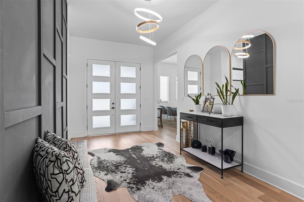 A modern entryway features a dark paneled wall, a cowhide rug, and a console table — 3306 W VAN BUREN DRIVE, TAMPA, FL