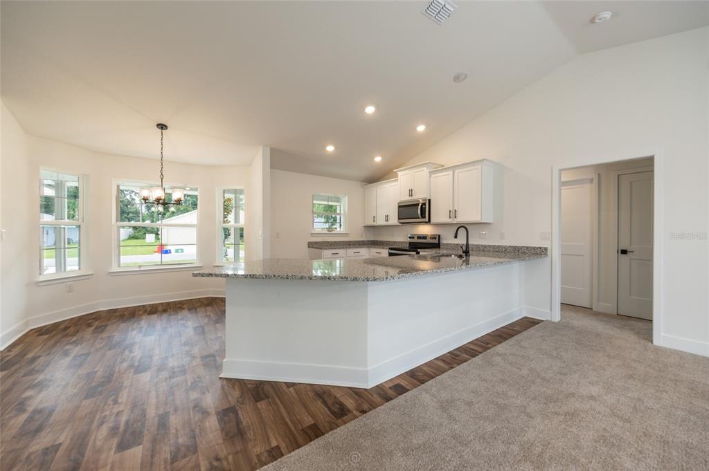 An entryway with a white door and a dining area featuring gray wood-look flooring — 21 RICHMOND DRIVE, PALM COAST, FL