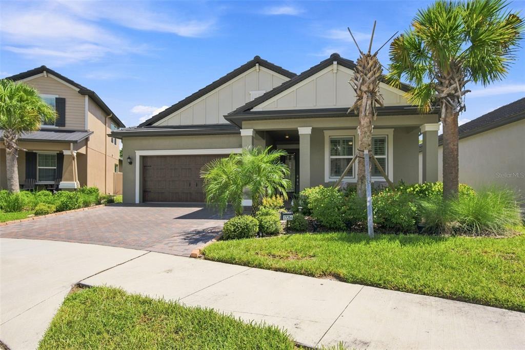 A single-story suburban house features a paved driveway, a two-car garage, and a front porch — 17254 MANGO SHAY COURT, LAND O LAKES, FL