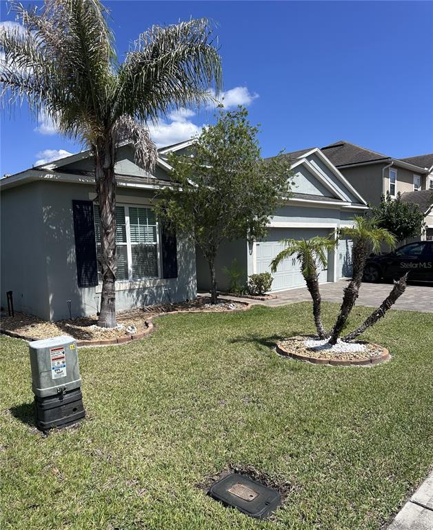 A single-story house with a palm tree, a small garden bed, and a driveway — 226 BRUNSWICK DRIVE, DAVENPORT, FL