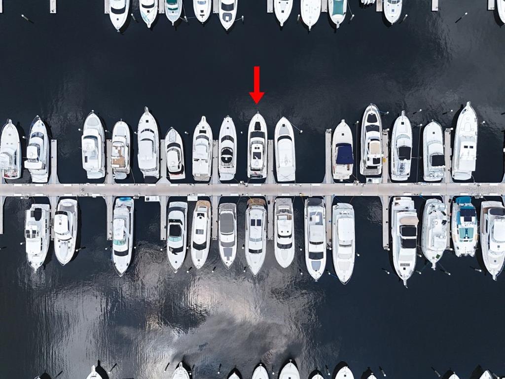 An aerial view shows a marina with numerous boats docked in slips along a pier — 102 RIVIERA DUNES WAY UNIT C-12, PALMETTO, FL