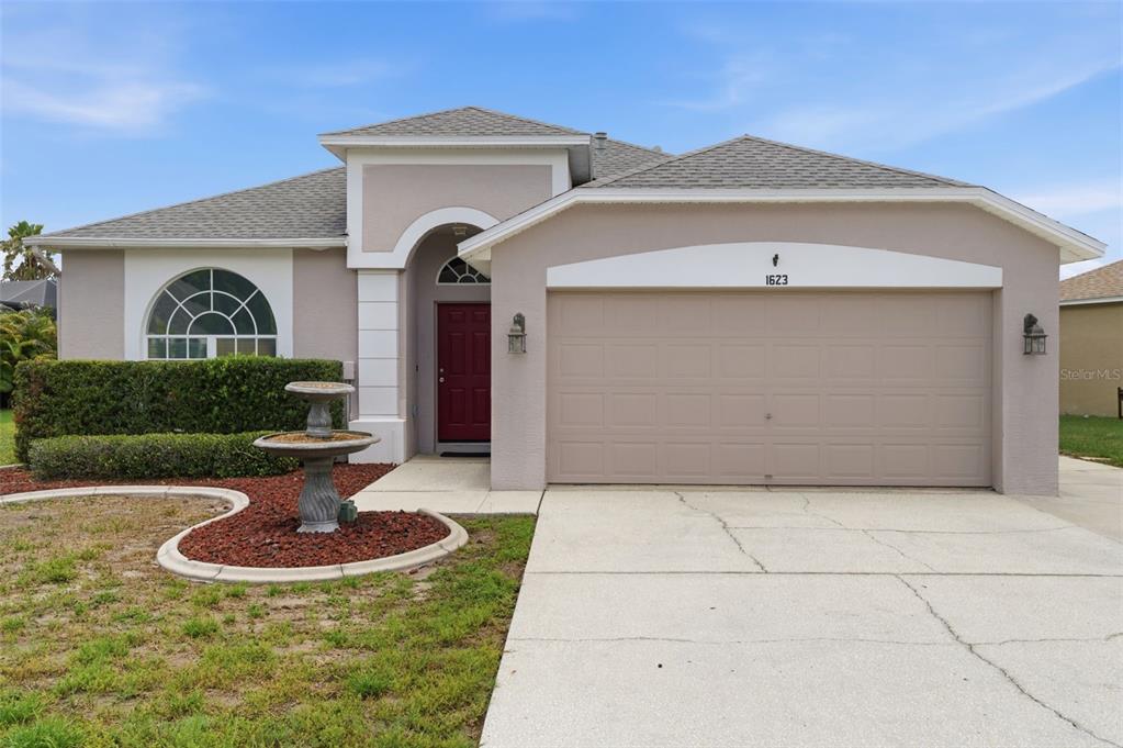 An empty room with light blue walls, hardwood floors, a ceiling fan, and arched windows — 1623 CROSSVINE COURT, TRINITY, FL