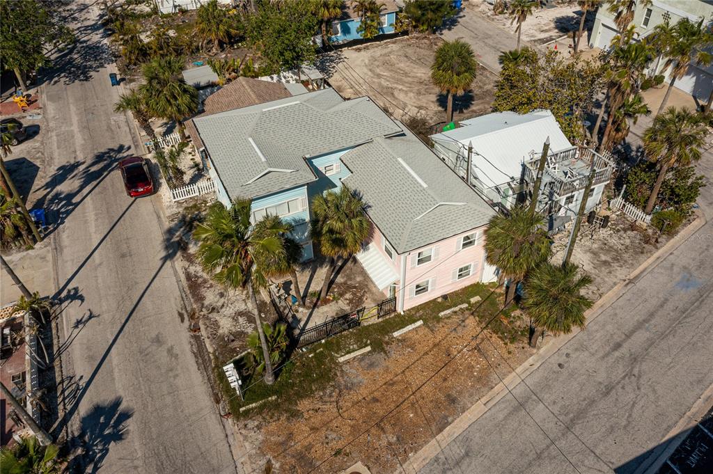 An aerial view shows a two-story house with a light blue and pink exterior — 134 86TH AVENUE, TREASURE ISLAND, FL