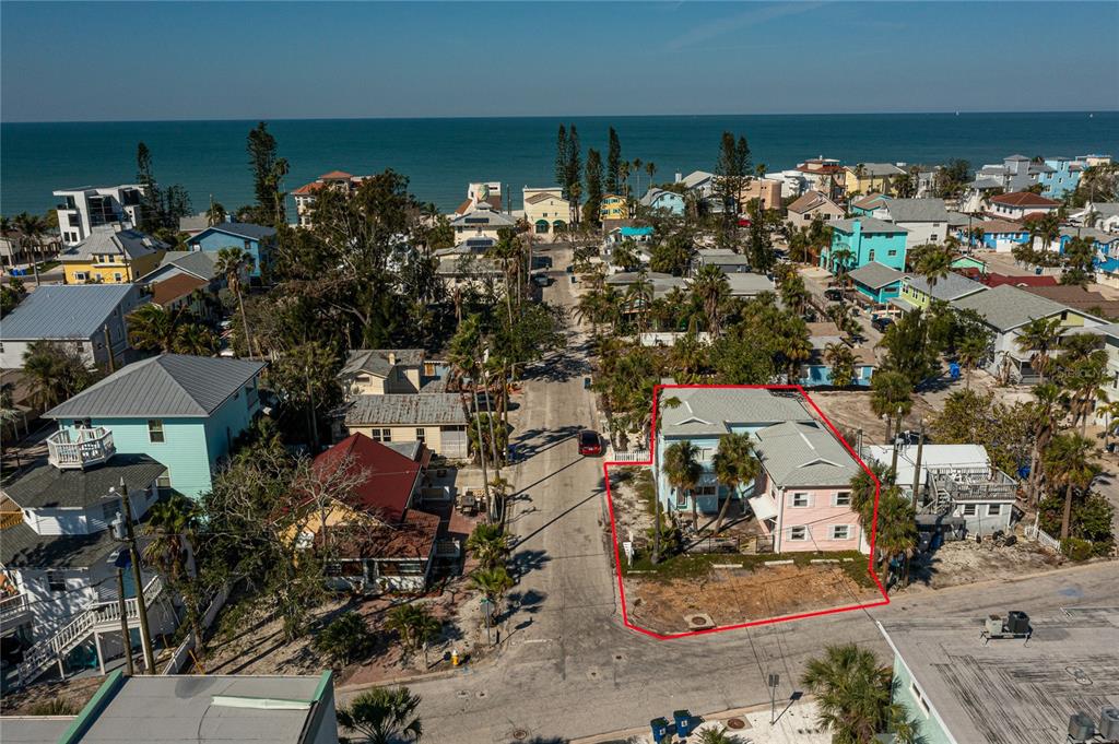 An aerial view shows a two-story house with a pink exterior outlined in red — 134 86TH AVENUE, TREASURE ISLAND, FL