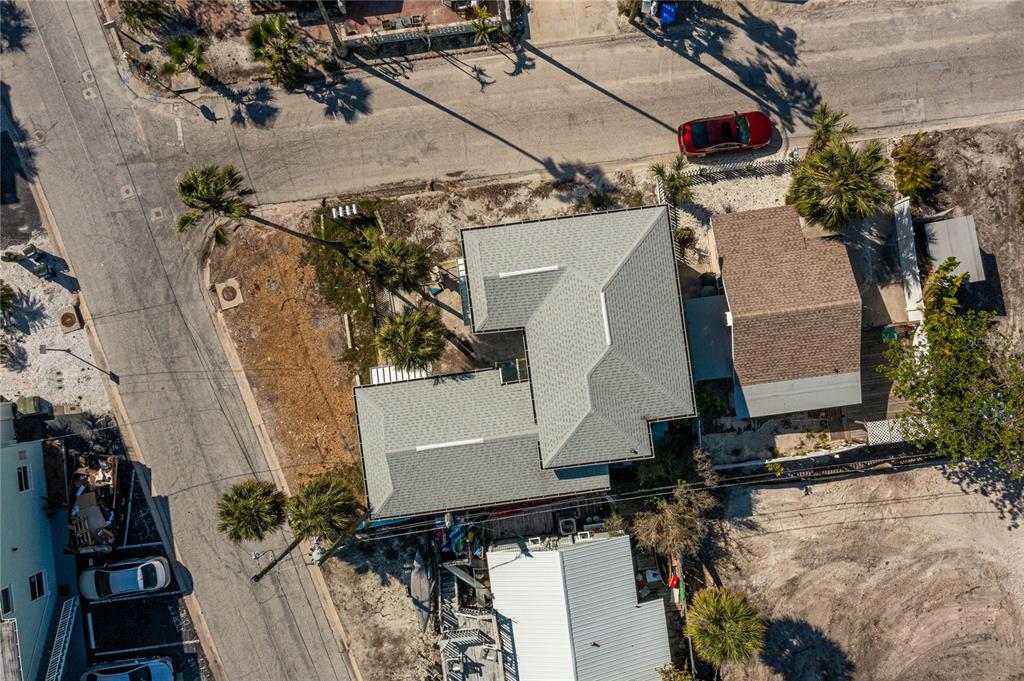 An aerial view shows a multi-level house with a gray roof next to a street — 134 86TH AVENUE, TREASURE ISLAND, FL