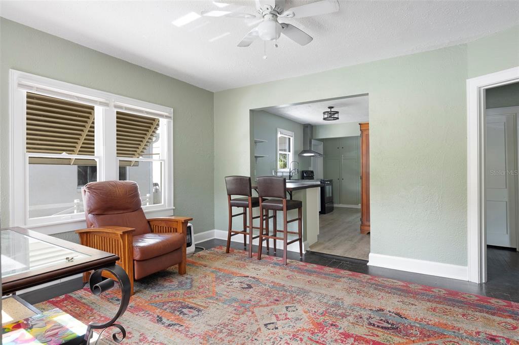 A living room features dark wood floors, a tufted sofa, and a ceiling fan — 2521 4TH STREET S, ST PETERSBURG, FL