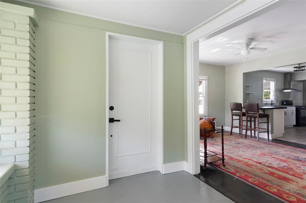 A living room with dark wood floors, a grey sofa, and a kitchen pass-through window — 2521 4TH STREET S, ST PETERSBURG, FL