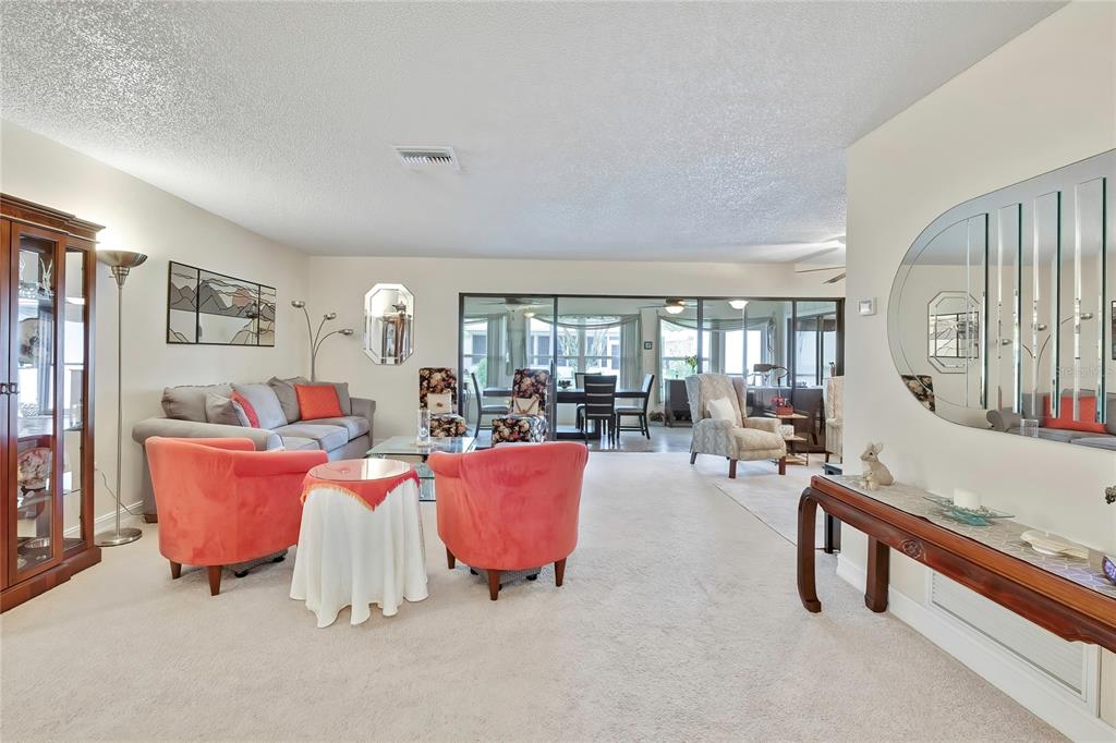 A single-story house with a brown shingled roof, two dormer windows, and a concrete driveway — 6433 LOST TREE LANE, SPRING HILL, FL
