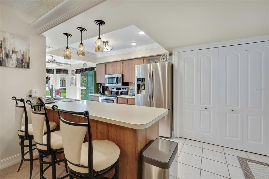 The exterior of a house features a paved patio, outdoor furniture, and a landscaped garden bed — 6433 LOST TREE LANE, SPRING HILL, FL