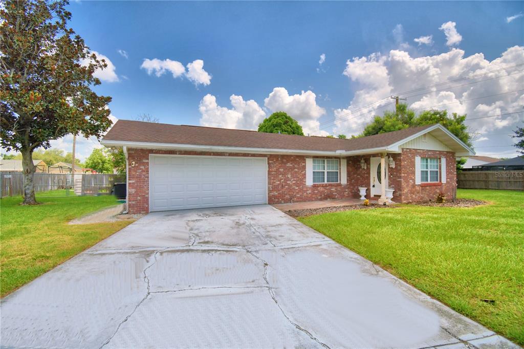 A single-story brick house with a two-car garage and a concrete driveway — 1206 SUSAN LANE, AUBURNDALE, FL