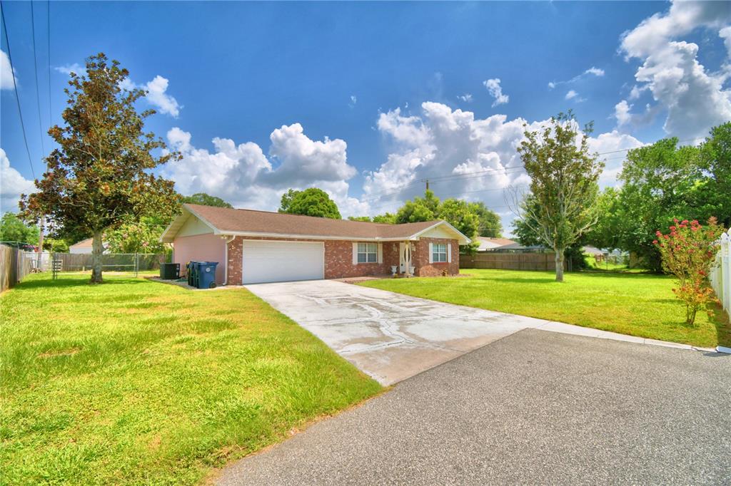A single-story brick house with a two-car garage and a concrete driveway — 1206 SUSAN LANE, AUBURNDALE, FL