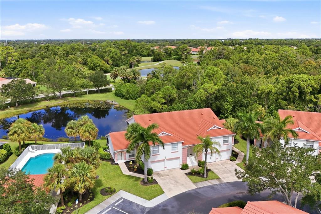 An aerial view shows a two-story house with a red tile roof and a pool — 7644 MARSH ORCHID CIRCLE, BRADENTON, FL