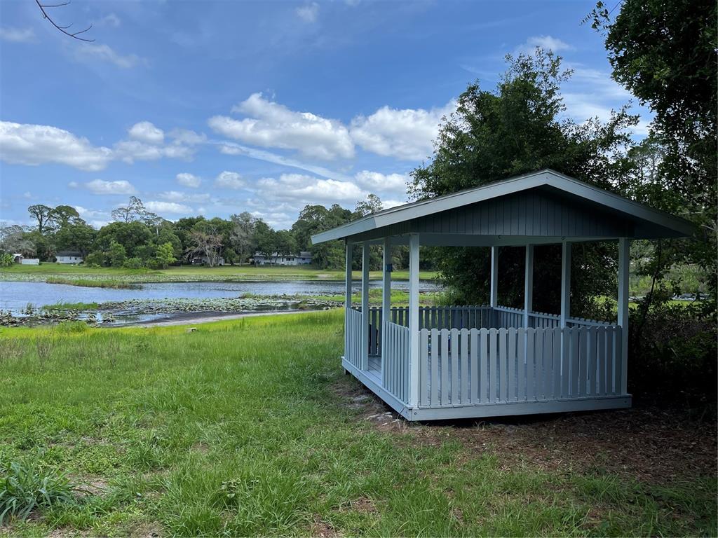 A single-story gray house with a chimney sits on a grassy lot under large trees — 119 MATANZAS ROAD, DEBARY, FL
