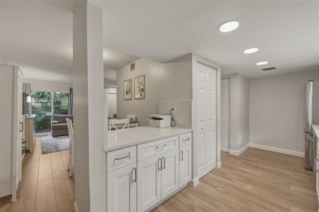 A kitchen with white cabinets and a countertop overlooks a living area with sliding doors — 7912 CEDAR DRIVE UNIT 7912, TEMPLE TERRACE, FL