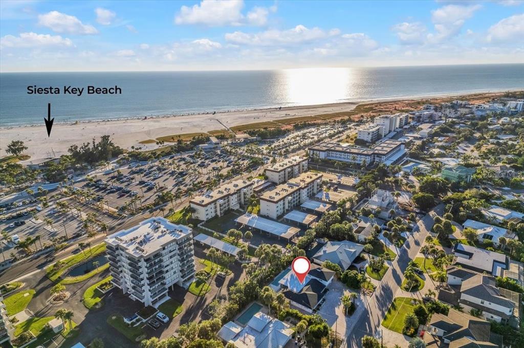 An aerial view shows a residential property near a large parking lot and beach — 5624 CAPE LEYTE DRIVE, SARASOTA, FL