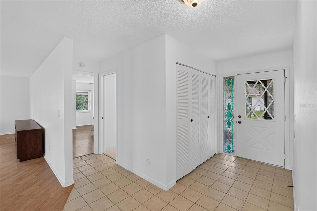 An entryway with tiled flooring, a white front door with stained glass, and a closet — 1308 LELAND DRIVE UNIT 1308, SUN CITY CENTER, FL