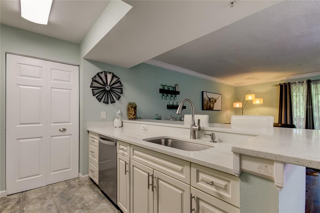 A two-story apartment building with tan stucco walls, a black metal staircase, and landscaping — 2400 FEATHER SOUND DRIVE UNIT 1228, CLEARWATER, FL