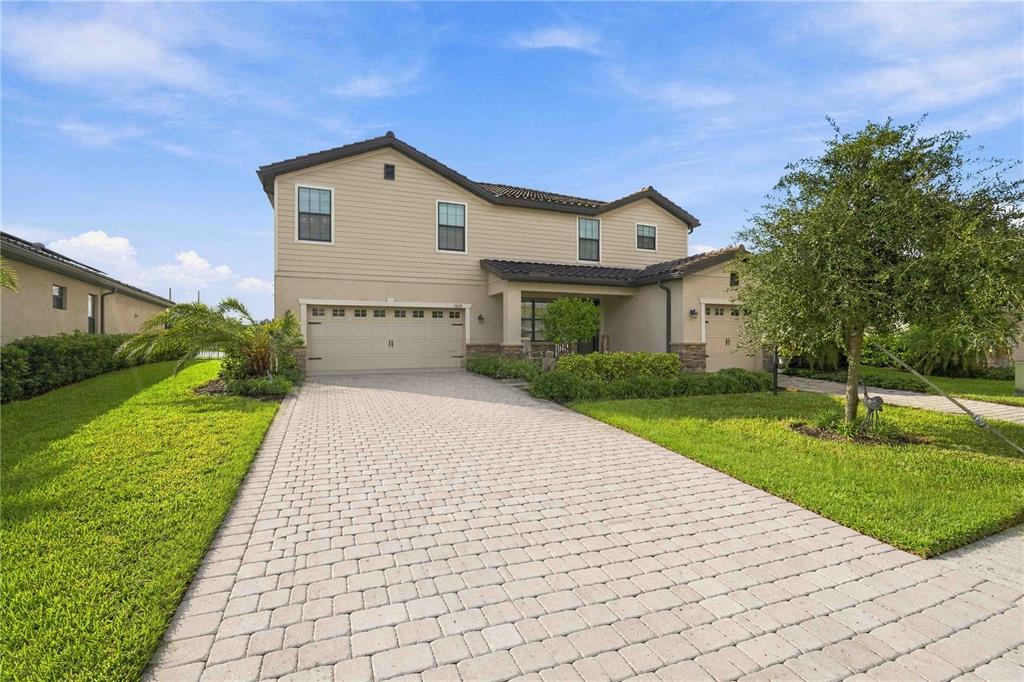 A two-story suburban house with a paved driveway, two garages, and a manicured front lawn — 17635 POLO TRAIL, BRADENTON, FL