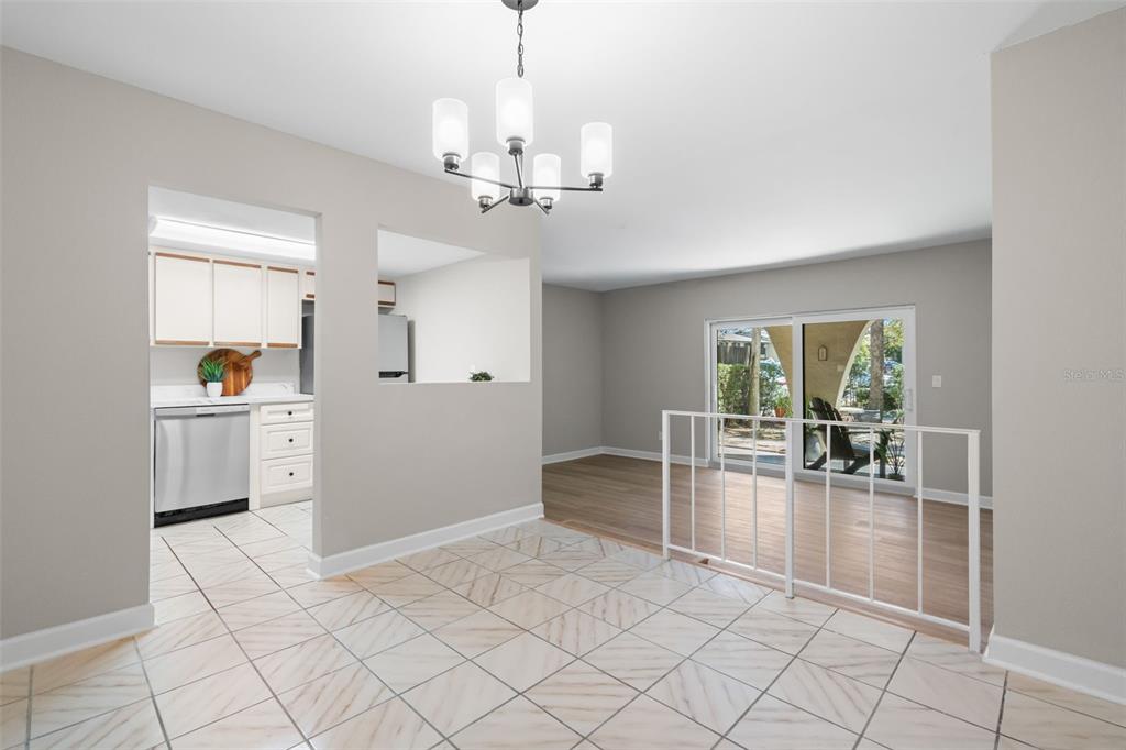 A kitchen features white cabinets, marble-patterned countertops, stainless steel appliances, and a corner sink — 505 PLAZA SEVILLE COURT UNIT 11, TREASURE ISLAND, FL