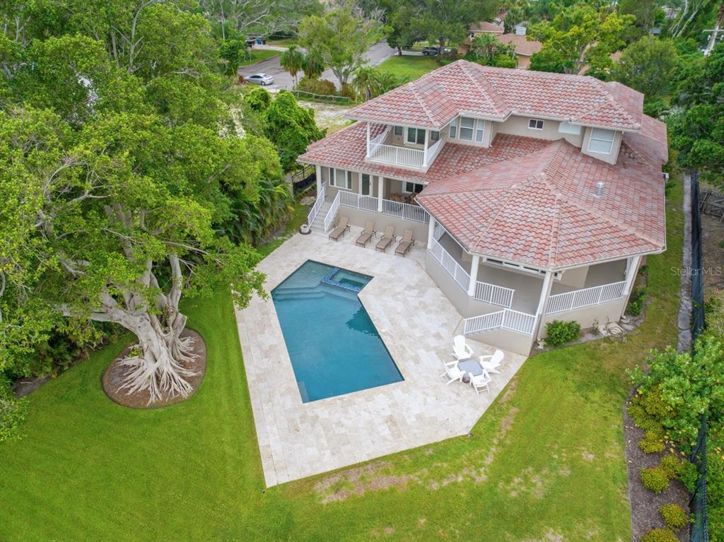 A two-story house with a tiled roof, beige stucco exterior, and a paved driveway — 5918 BAHAMA SHORES DRIVE S, ST PETERSBURG, FL