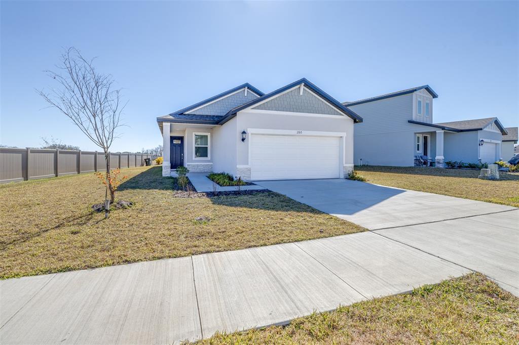 A single-story house with a white garage, gray siding, and a small front yard — 2707 VIRGINIA PINE DRIVE, BARTOW, FL