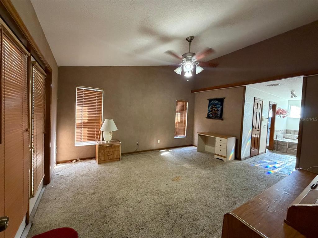 A carpeted room features a ceiling fan, two windows with blinds, and a small desk — 215 SANTA ROSA DRIVE, WINTER HAVEN, FL