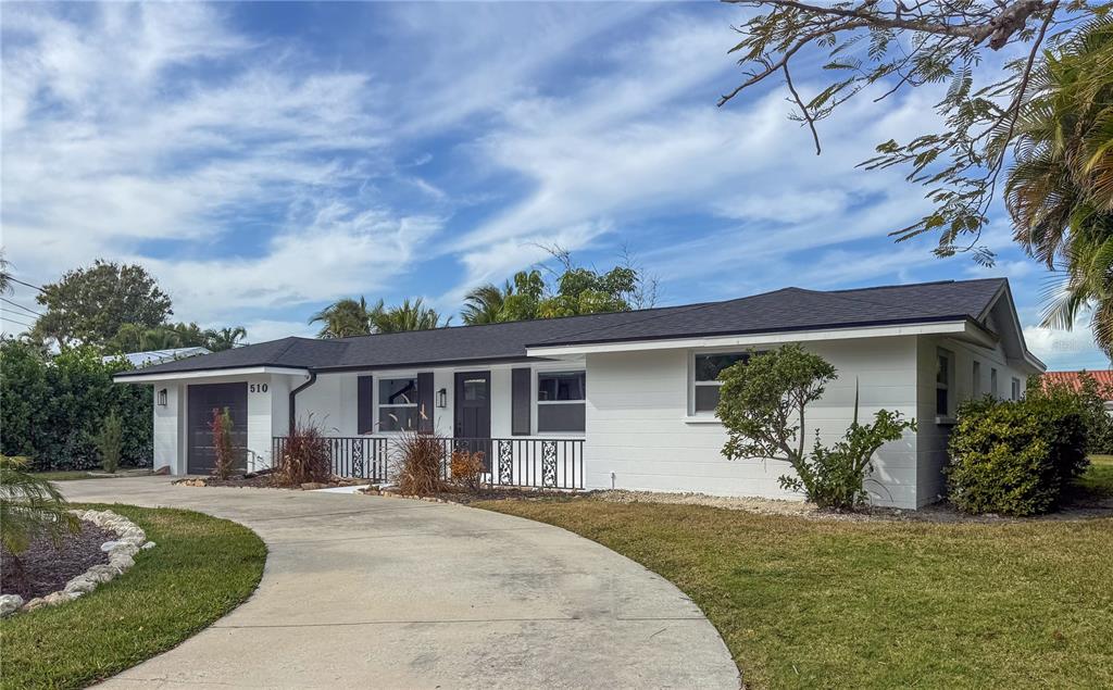 A single-story white house with a dark roof, a curved driveway, and a front porch — 510 69TH STREET, HOLMES BEACH, FL