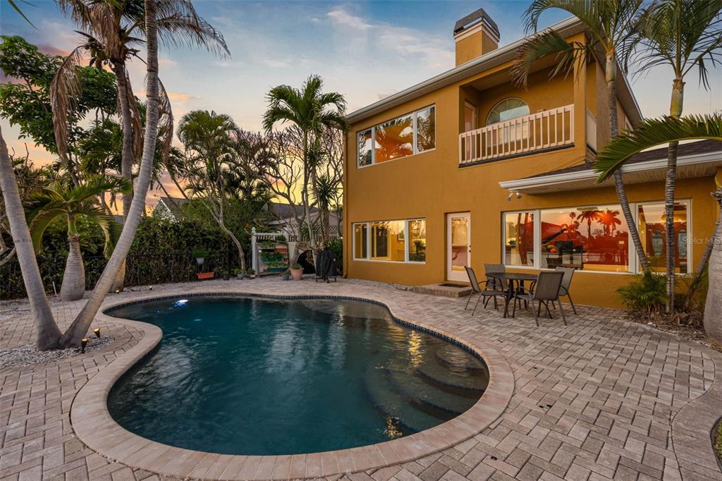 A two-story house with a backyard swimming pool and a paved patio area — 11260 5TH STREET E, TREASURE ISLAND, FL