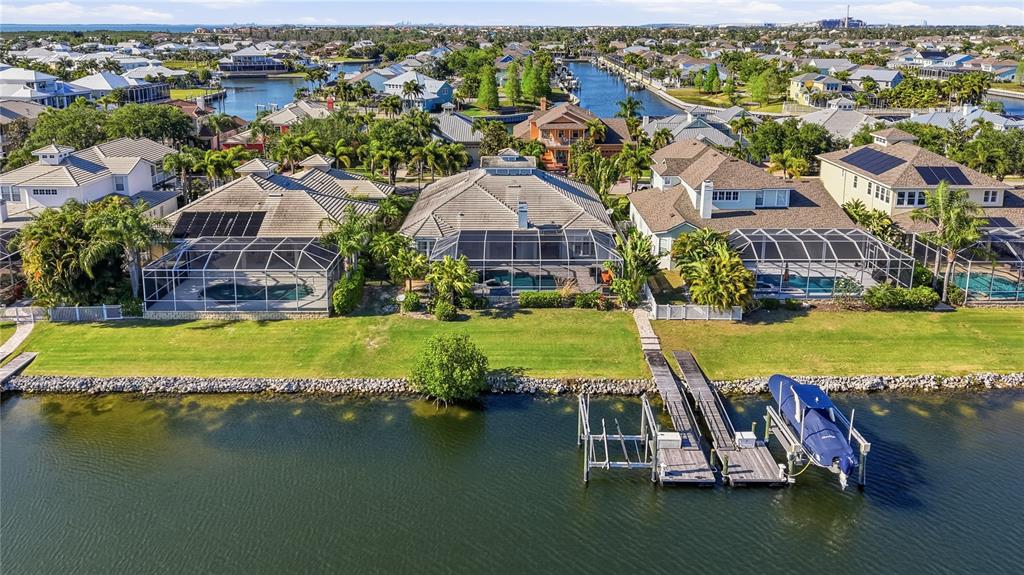 An aerial view shows waterfront houses with screened-in pools and private boat docks — 510 MIRABAY BOULEVARD, APOLLO BEACH, FL