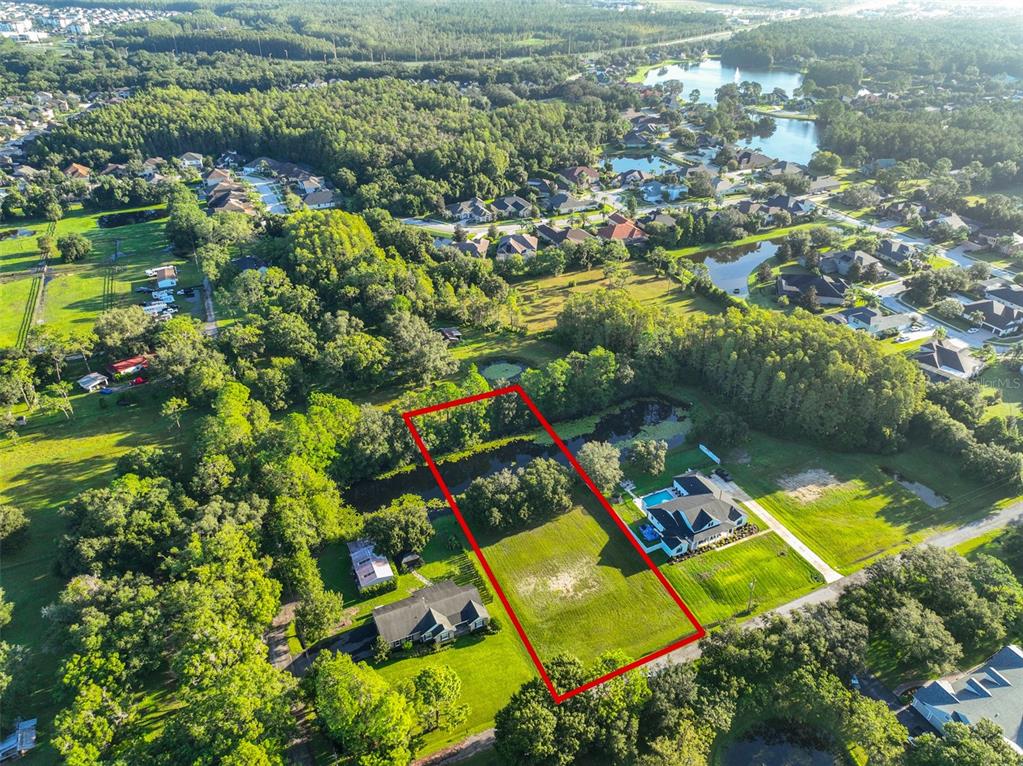 An aerial view shows a rectangular vacant lot outlined in red next to a house — 0 PHILLIPS ROAD UNIT 2, ODESSA, FL