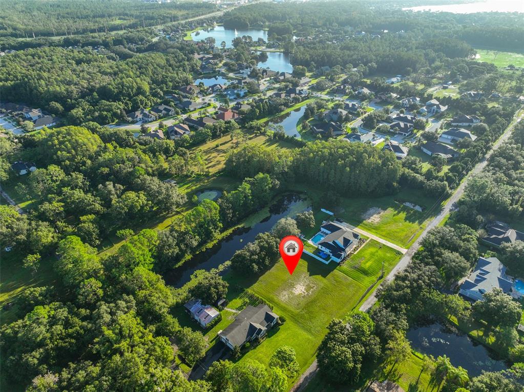 An aerial view shows a residential property with a house, pool, and pond — 0 PHILLIPS ROAD UNIT 2, ODESSA, FL