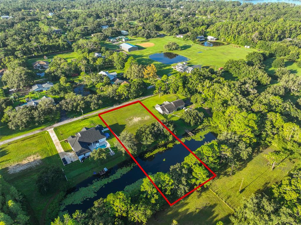 An aerial view shows a rectangular vacant lot outlined in red next to a canal — 0 PHILLIPS ROAD UNIT 2, ODESSA, FL