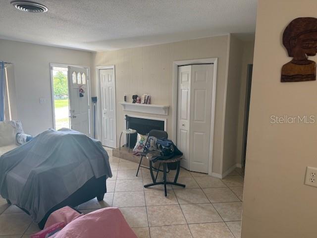 A living room features a fireplace, tiled floors, and a covered piece of furniture — 2108 WOLF ROAD, ORLANDO, FL