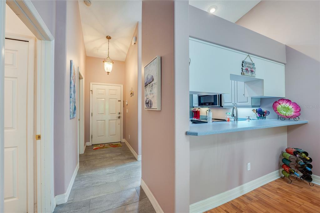 A view of an entryway with tile flooring leading to a kitchen with a breakfast bar — 1413 COCONUT PALM CIRCLE, PORT ORANGE, FL