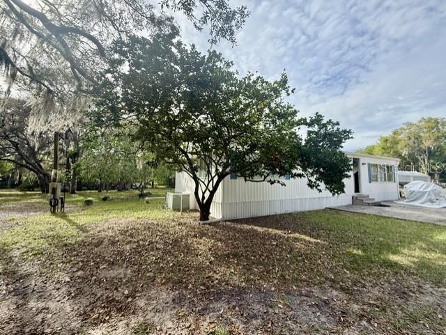 A white mobile home sits on a grassy lot shaded by a large tree — 2424 JUNIOR AVE. Unit B, APOPKA, FL