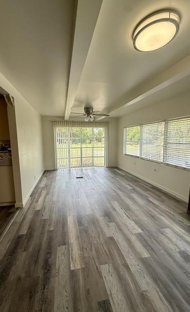 A living room features light wood-look flooring, a ceiling fan, and large windows with blinds — 2424 JUNIOR AVE. Unit B, APOPKA, FL