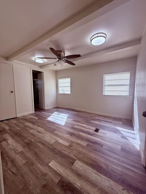 An empty bedroom features wood-look flooring, a ceiling fan, and two windows — 2424 JUNIOR AVE. Unit B, APOPKA, FL