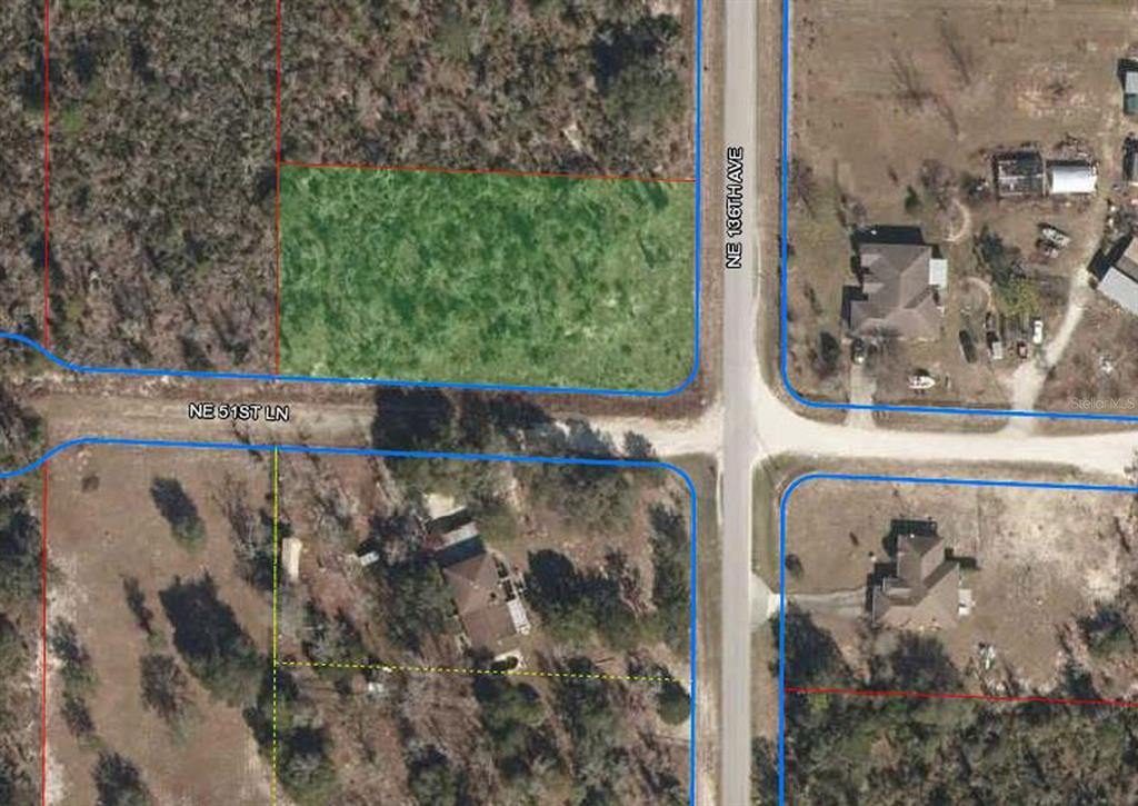 This is an aerial map showing a vacant, rectangular lot highlighted in green at an intersection — 13591 NE 51ST LANE, WILLISTON, FL