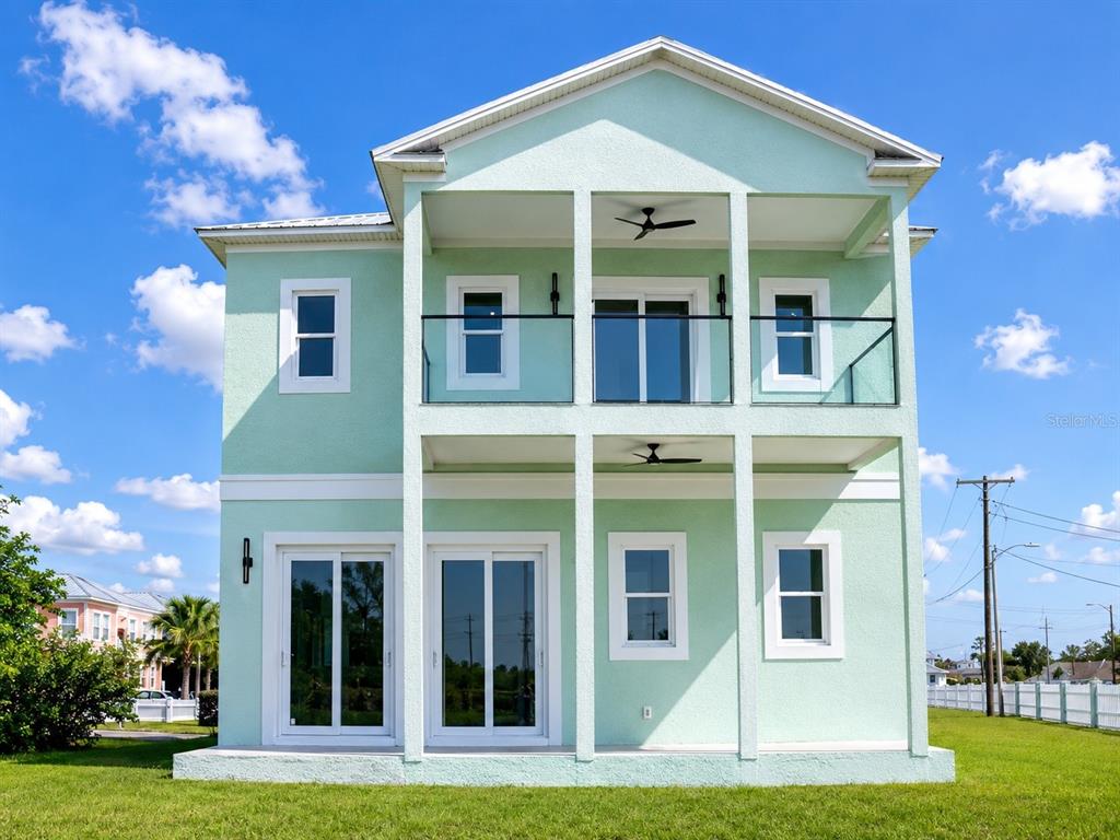 A two-story, light green house with a garage and a second-floor balcony — 6510 SIMONE SHORES CIR, APOLLO BEACH, FL