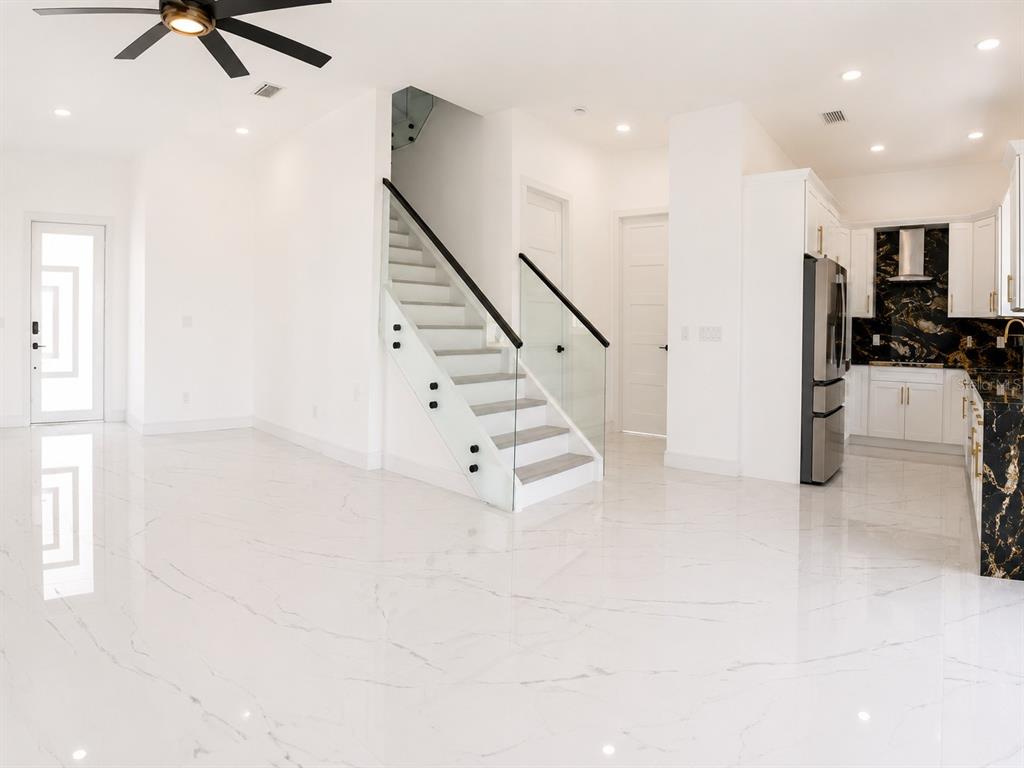 A two-story light green house features a covered porch and a second-floor balcony — 6510 SIMONE SHORES CIR, APOLLO BEACH, FL