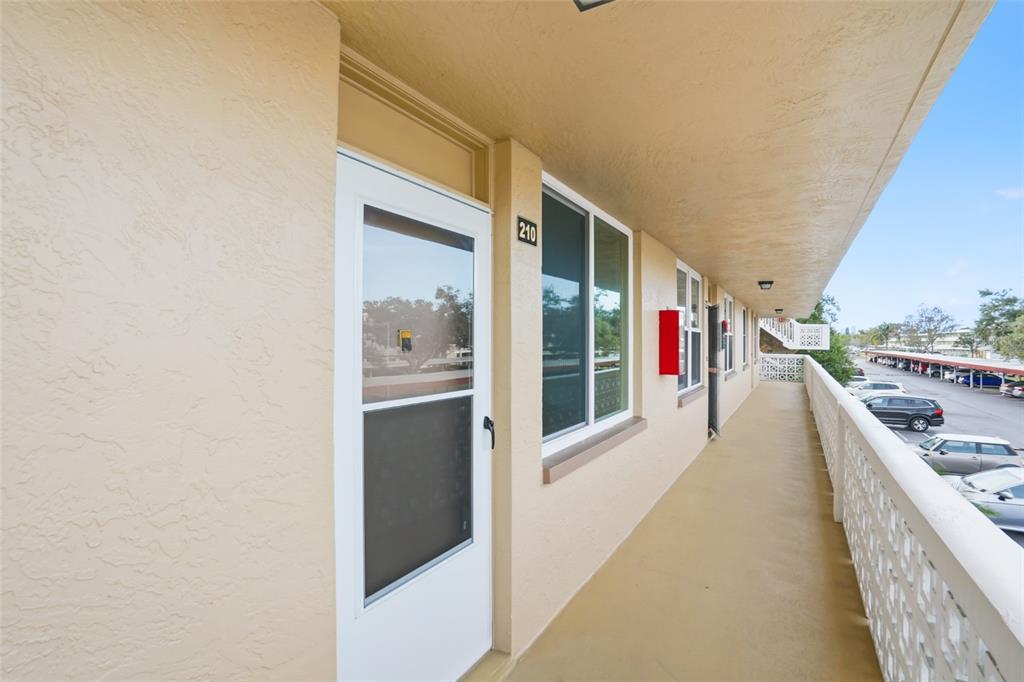 An aerial view shows a community clubhouse with a swimming pool and tennis courts — 5095 BAY STREET NE UNIT 210, ST PETERSBURG, FL